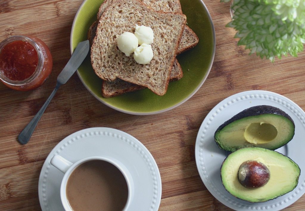 vue de dessus table avec café tartines confiture et avocats