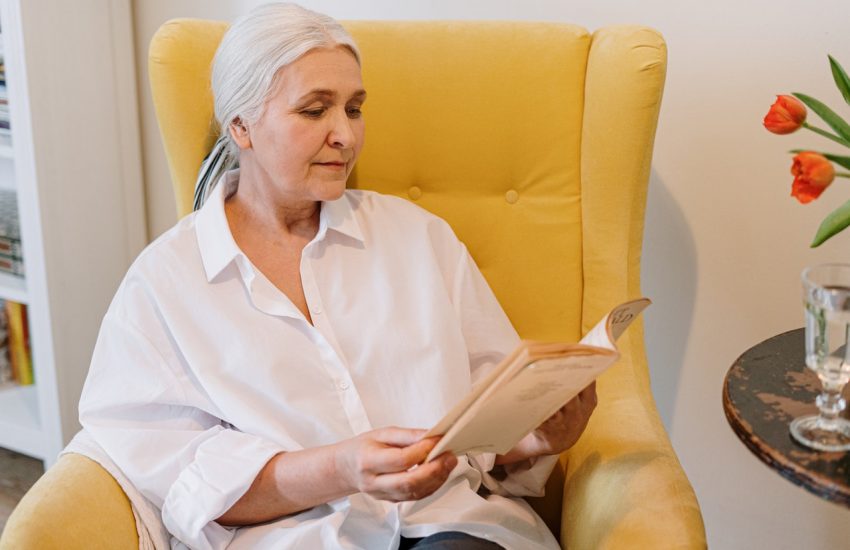 femme âgée assise dans un fauteuil jaune